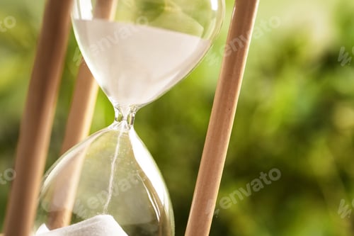 Preview: Hourglass with flowing sand on blurred background, closeup. Time management