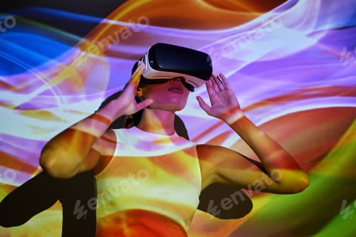 Preview: Confident young woman adjusting her virtual reality glasses against colorful background