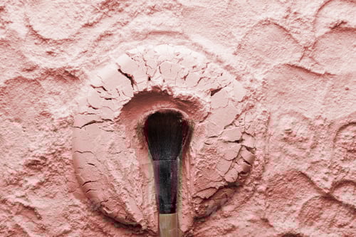 Preview: Makeup brushes on pink cosmetic powder background. Flat lay, top view.