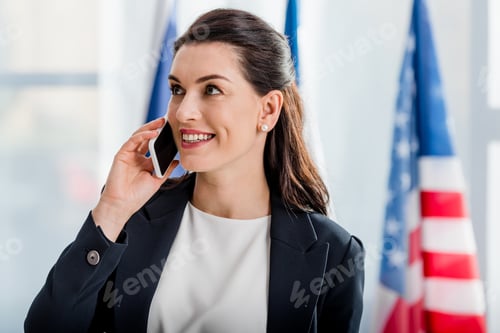 Preview: happy diplomat talking on smartphone near american flag