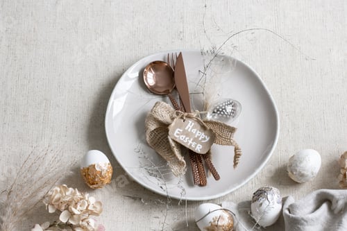Preview: Festive Easter table setting with decor details on white table.