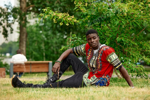 Preview: An African man in South African national clothes, a black young man resting in a park in national