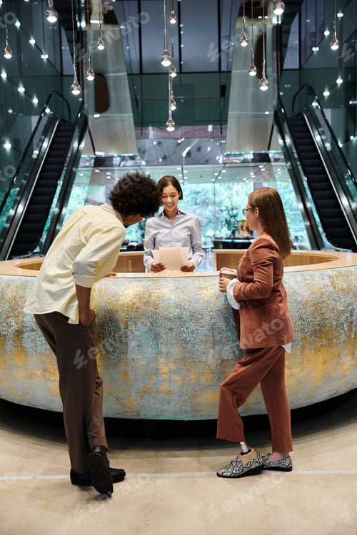 Preview: Diverse colleagues chatting in modern lobby