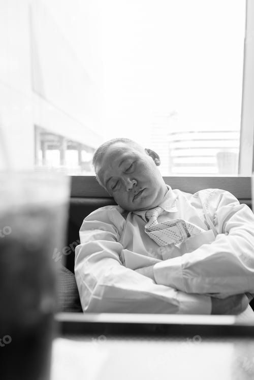 Preview: Mature Asian businessman relaxing inside the restaurant at the mall