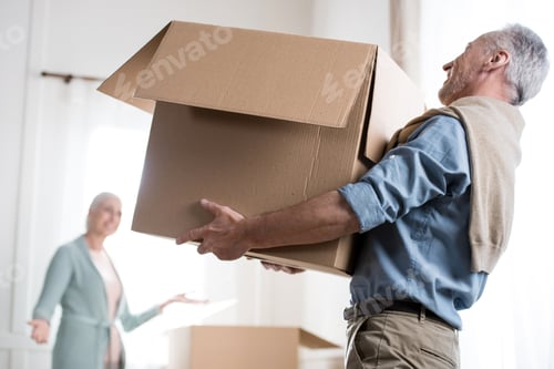 Preview: side view of man holding heavy cardboard box at new home