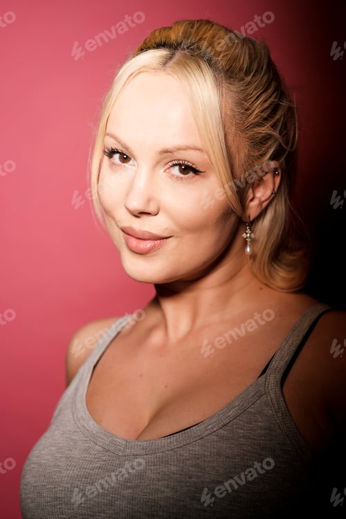 Preview: Portrait of smiling blonde woman with gray tank top on pink background