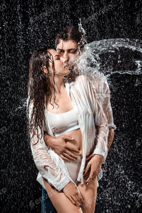 Preview: portrait of seductive couple swilled with water isolated on black