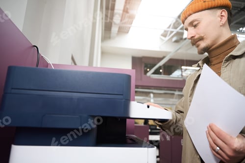 Preview: Focused company employee using copy machine in office