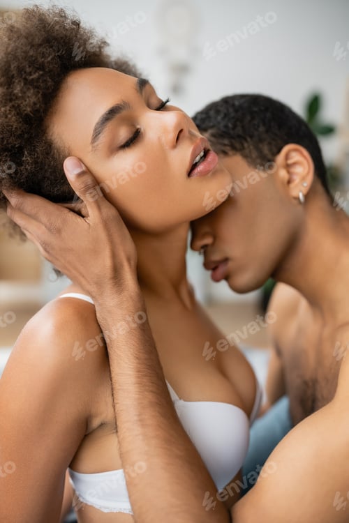 Preview: hot african american woman in white bra standing with closed eyes near shirtless boyfriend