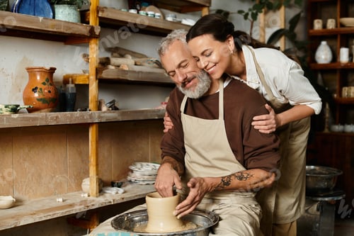 Preview: A mature couple joyfully shaping clay while enjoying quality time in a pottery studio.