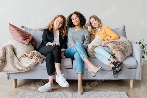 Preview: Happy restful girls in casualwear relaxing on couch at home