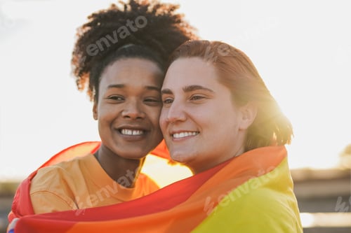 Preview: Multiracial female couple having tender moment at sunset - LGBT concept