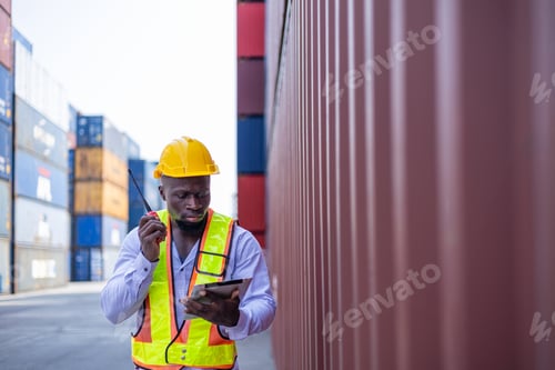 Preview: Black engineer in warehouse inspecting goods at industrial container yard