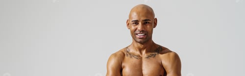 Preview: Portrait of smiling sporty man with muscled naked body on white studio background