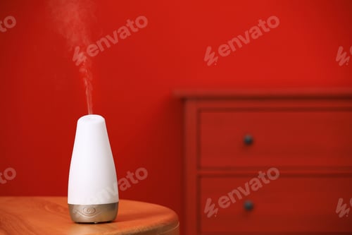 Preview: Modern essential oil diffuser on table indoors. Space for text