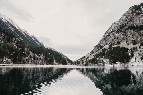 Preview: Wonderful lake between hills in snow and cloudy sky