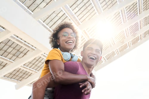 Preview: Young smiling lovers looking at the camera. The girl is piggyback on her boyfriend.