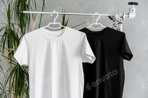 Preview: White and black T-shirts on hangers for design presentation