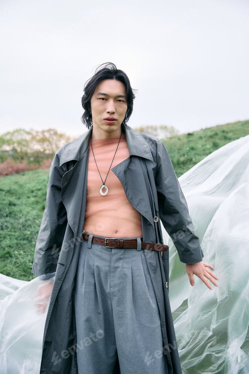 Preview: Stylish young man showcasing modern fashion in a serene park setting