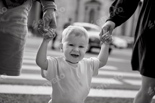 Preview: baby boy crossing road on zebra crossing holding parents by hands in city of Saint Petersburg