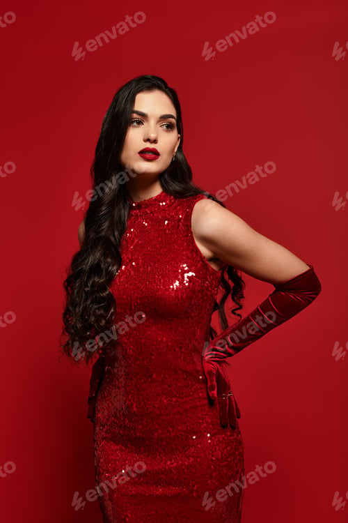 Preview: Elegant young woman in stunning red attire poses against a vibrant backdrop