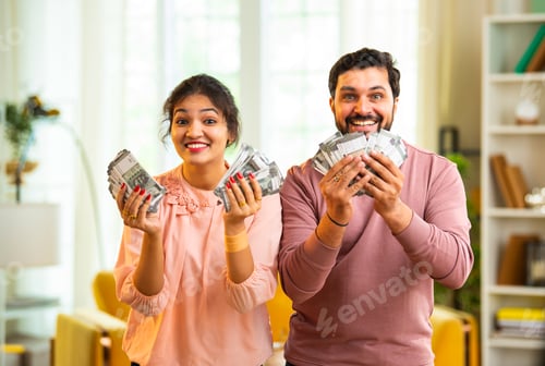 Preview: Happy Indian couple holding and showing rupee notes, symbolizing unexpected financial success