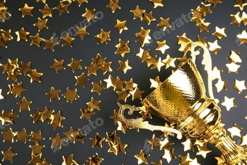 Preview: Gold trophy cup and confetti on black background, flat lay. Space for text