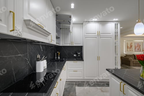Preview: Closeup to black granite worktop of white domestic kitchen with marble floor
