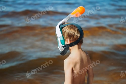Preview: cute little caucasian boy wearing snorkeling mask going to swim in the sea