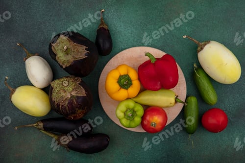 Preview: top view white and black eggplant with bell peppers tomatoes on a stand and cucumbers on a green