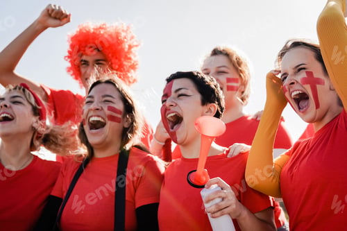 Preview: Red sport football fans celebrate team victory in championship soccer game at stadium crowd