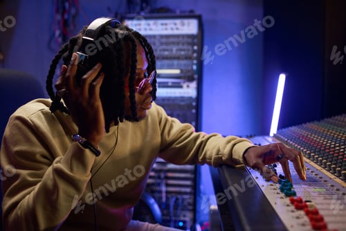Preview: Man adjusting audio control panel in sound studio