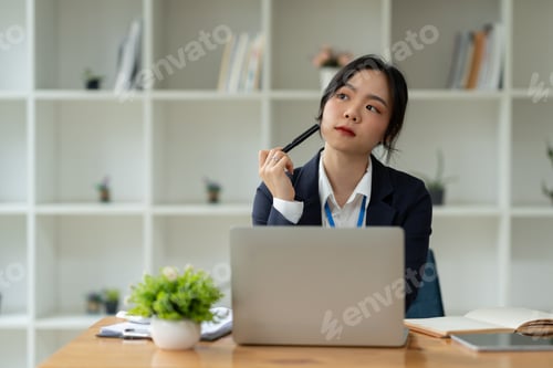 Preview: Asian young woman businesswoman using laptop computer with working papers planning idea idea to anal