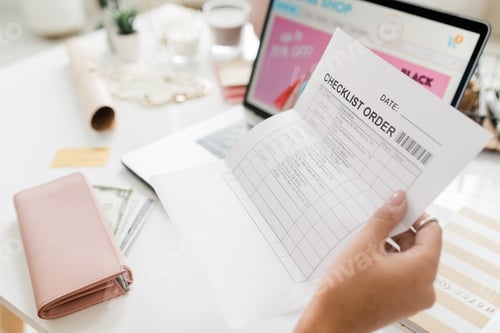 Preview: Female hand holding paper with checklist after making order in online shop
