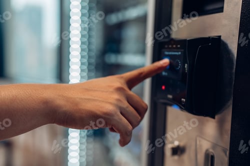 Preview: woman's finger pushing number button on keyboard of snack vending machine.