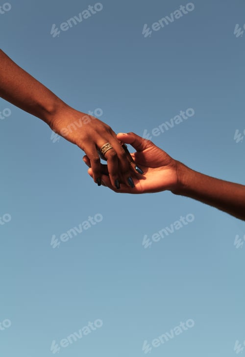 Preview: Black couple holding hands against blue sky