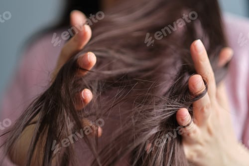 Preview: woman touches tangled dry hair. hair care in winter. Long Disheveled Hair, Holding Messy Hair