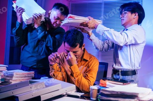 Preview: Three young businessmen work together on laptops in the office at night. They are stressed tired