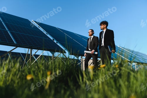 Preview: Investors walking and discussing next to solar panels in sustainable energy plant