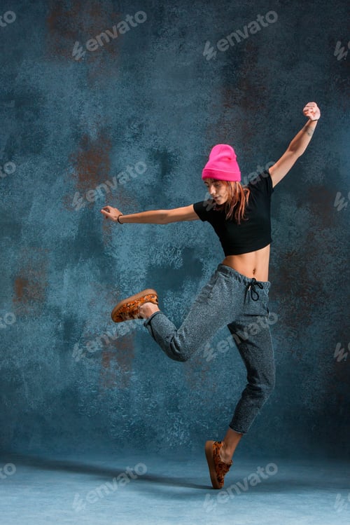 Preview: Young girl break dancing on wall background.