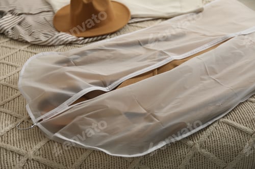 Preview: Garment cover with clothes on bed indoors, closeup