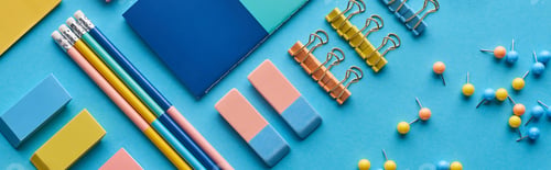 Preview: panoramic shot of pencils, push pins and colorful stationery isolated on blue