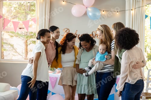 Preview: Group of diverse women celebrating baby shower with joy and laughter at home