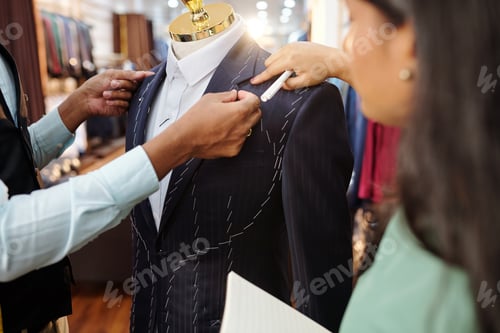 Preview: Professional Tailors Adjusting Custom Suit in Modern Shop