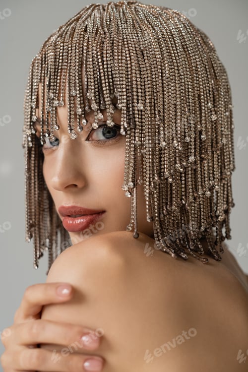 Vista previa: Portrait of woman with naked shoulder and jewelry headwear looking at camera isolated on grey