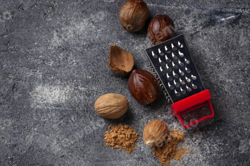 Nutmeg and Grater on a Textured Dark Surface