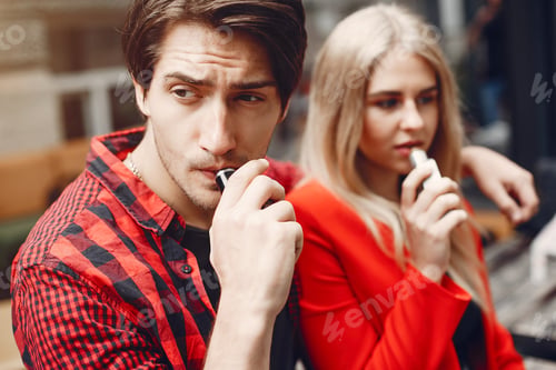 Preview: Stylish young couple with vape in a city