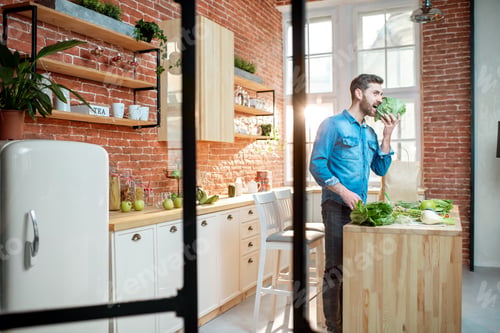 Preview: Man with healthy food on the kitchen