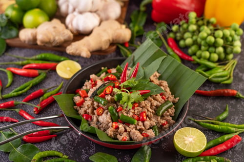 Preview: Stir-fried pork basil on banana leaves in a frying pan.