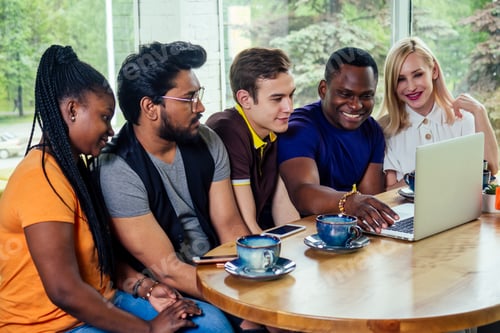 Preview: multinational group of happy friends enjoy and drinking tea cafe looking at the laptop